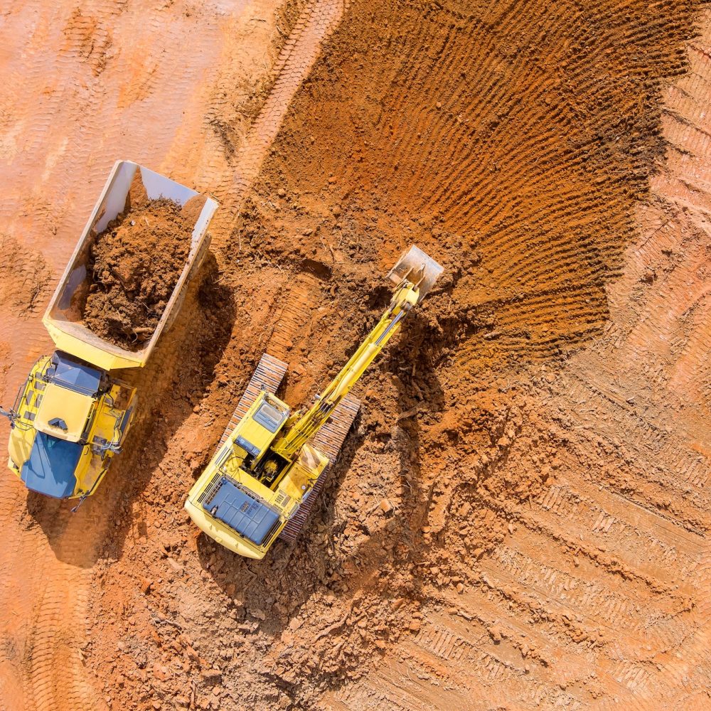 Backhoe working by digging soil at bucket teeth of backhoe digging soil and loads a dump truck with